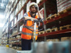 Tired worker with forklift touching his forehead